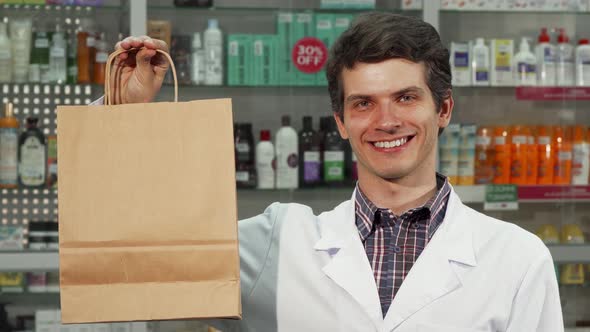 Cheerful Pharmacist Holding Shopping Bag Smiling To the Camera