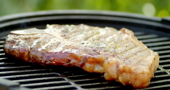 Steak T-bone Is Grilled with Smoke.