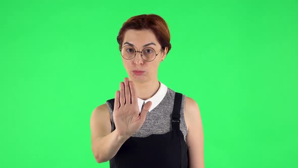 Portrait of Funny Girl in Round Glasses Strictly Gesturing with Hands Shape Meaning Denial Saying NO