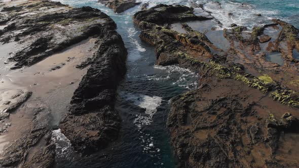 Slow tilt reveals the relaxing flow of the tide pools on the shore of Porto das Salemas