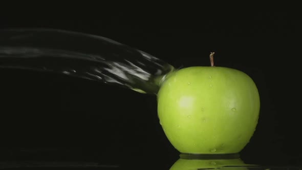 Water Flow Falls On A Green Apple On A Black Background