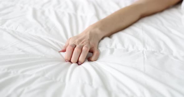 Woman Hand Clenches Hand Into Fist with Blanket