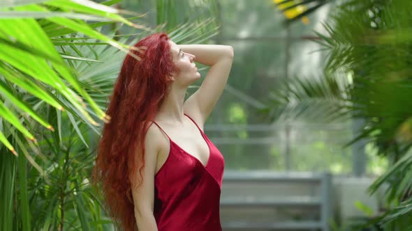 Young redhead woman in a greenhouse