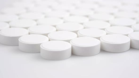 Many White Medical Pills Rotating Close Up