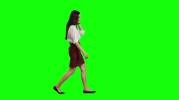 Manager Girl Goes To Her Phone Rings and She Starts Talking. Green Screen. Side View