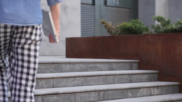 Man Coming and Sitting on Stairs and Working on Laptop