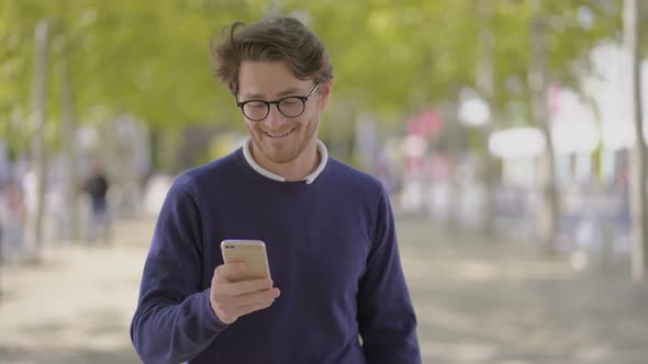 Happy Man in Eyeglasses Using Cell Phone Outdoor