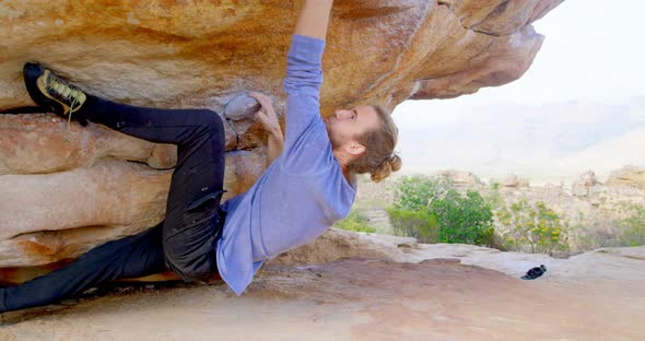 Male hiker climbing rocky mountain in countryside 4k