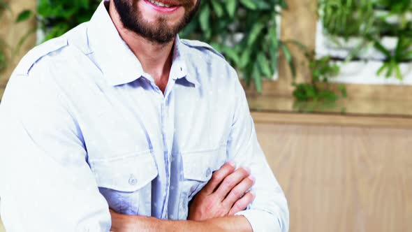 Portrait of smiling male executive standing with arms crossed