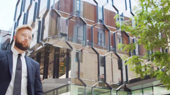 Confident businessman in front of modern office building. Financial investor outdoor.