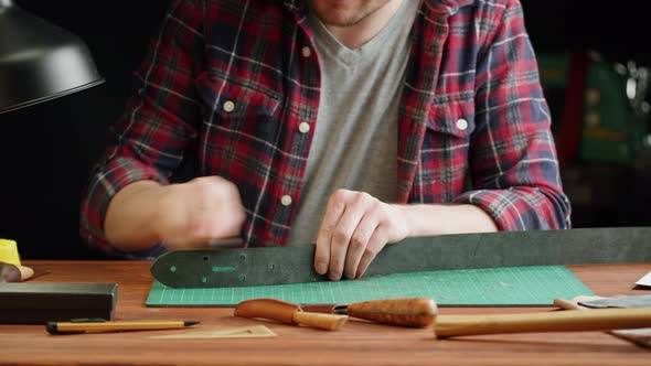 Man Tailor Polishing Artificial Leather Closeup