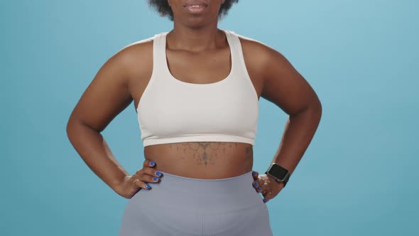 Black Plus Size Woman in Sportswear on Blue Background