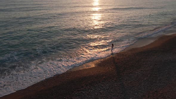 Extreme Wide Shot Cyprus Seascape in Sunbeam with Young Slim Woman Standing on Beach