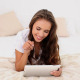 Young Woman Using Her Tablet Lying On Her Bed - VideoHive Item for Sale