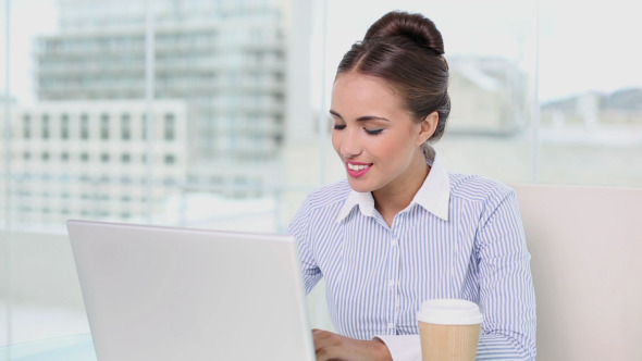 Young Businesswoman Working On Her Laptop Drinking