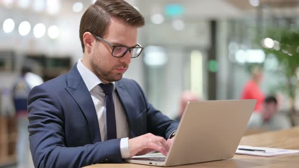 Young Businessman at Work Using Laptop 