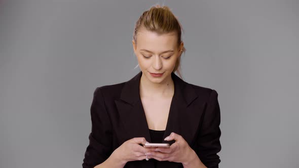 Stylish Businesswoman Browsing Smartphone in Studio