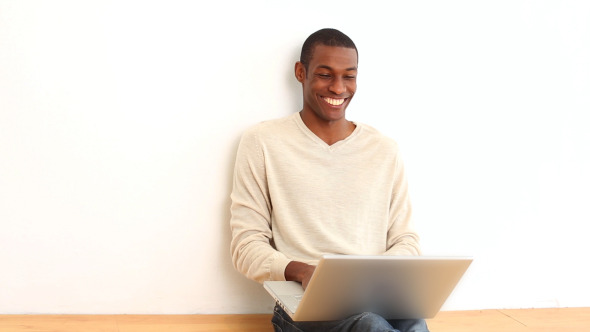 Happy Man Using Laptop Sitting On The Floor alt