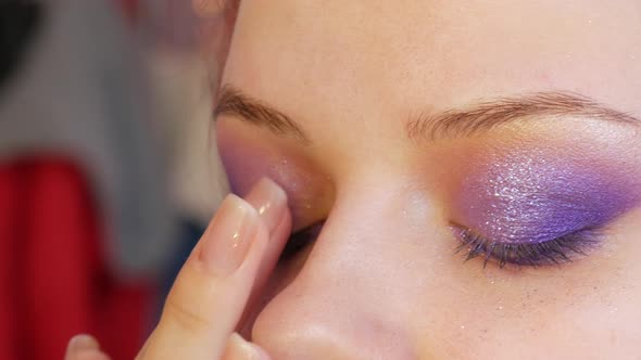 Beautiful Shiny Violetlilac Shadows are Applied with a Special Brush on the Eyelid of the Model