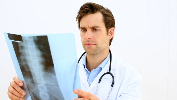 Focused Doctor Looking At Xray