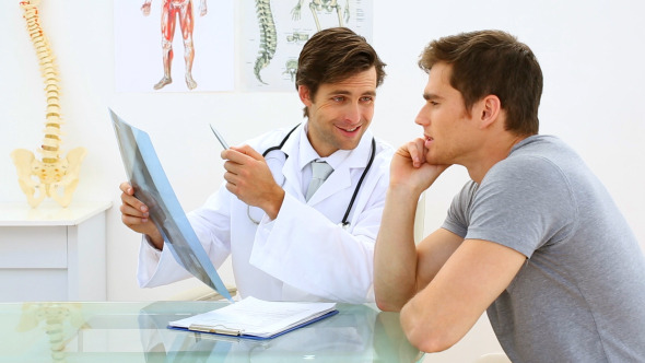 Smiling Doctor Discussing Xray With His Patient