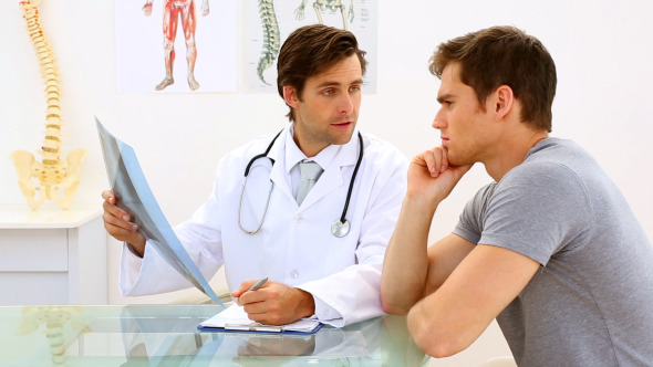 Earnest Doctor Discussing Xray With His Patient