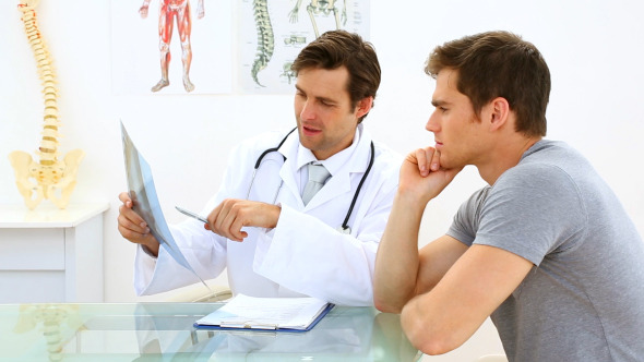 Handsome Doctor Discussing Xray With His Patient