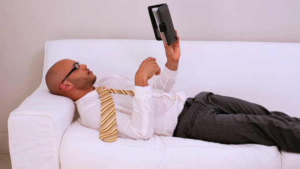 Tired Businessman Falling Asleep On Couch