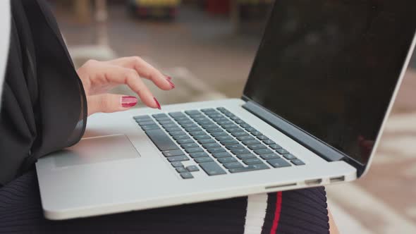 Woman Sat Outside Inputting Data Onto Her Laptop, In Slow Motion