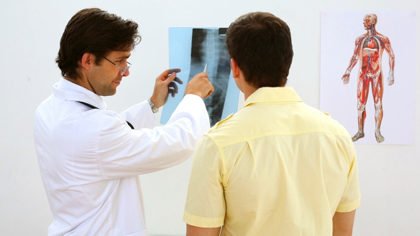 Doctor Looking At Xray With Patient And Smiling