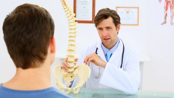 Doctor Showing Patient A Spine Model