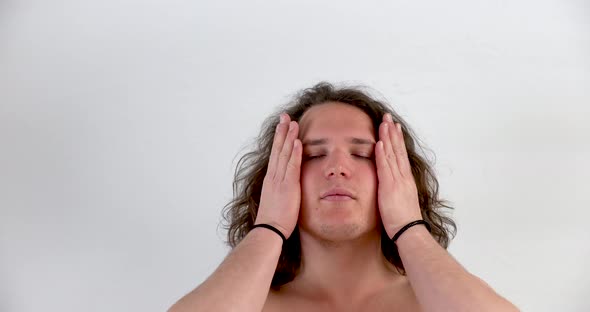 Young white man with blond hair without t shirt showing how he combs his hair without a mask in clos