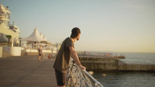 Handsome Young Guy Meeting New Day Near Seaside Enjoying Sunlights Watching Into Distance with