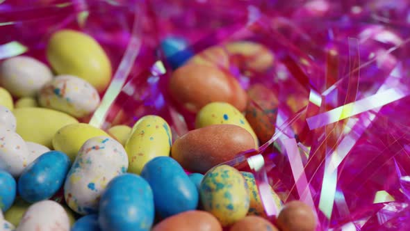 Rotating shot of colorful Easter candies on a bed of easter grass 