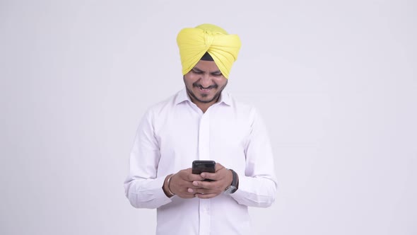 Happy Bearded Indian Sikh Businessman Using Phone