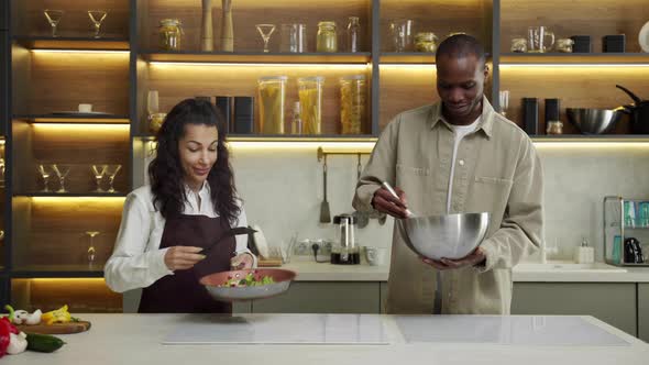 Young Couple Chefs Cook Delicious Dish for Dinner in Kitchen