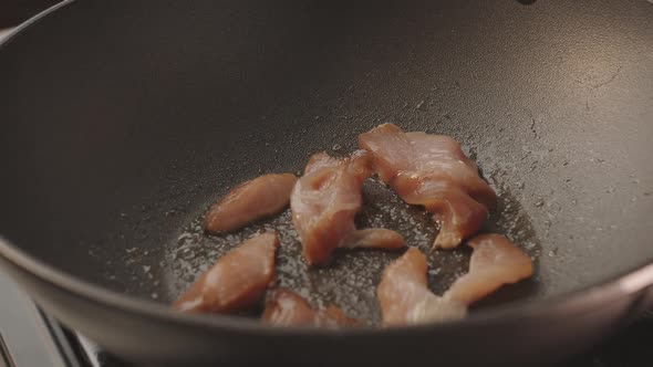 Cooking Chicken in a Pan in the Kitchen