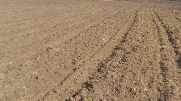 Furrows in the soil made by plough 4K drone footage