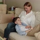 Teenager Lies on the Lap of an Adult Woman She Strokes His Head - VideoHive Item for Sale