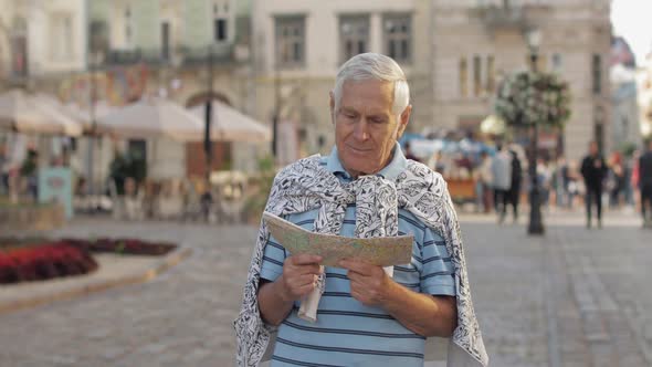 Senior Male Tourist Exploring Town with a Map in Hands. Looking for the Route