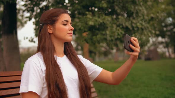 Caucasian Brunette Use App on Mobile Outdoors