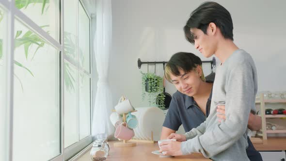 Asian man gay family standing on counter, drink coffee for breakfast. Homosexual-LGBTQ concept.