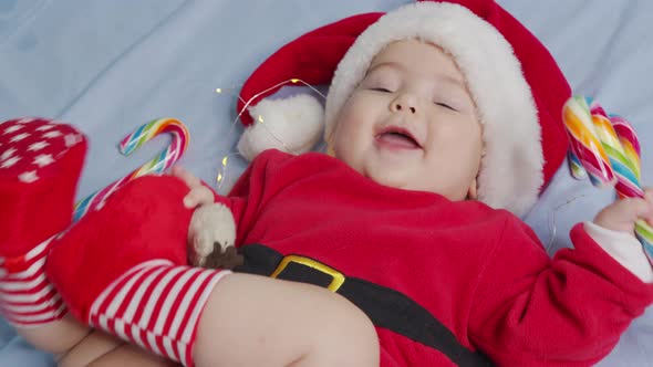 Christmas Portrait of Cute Little Newborn Baby Girl Wearing Santa Hat and Dress Winter Time