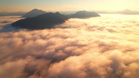 4K Aerial video Beautiful sunrise above dense clouds and fog in the morning, Cinematic drone shot.
