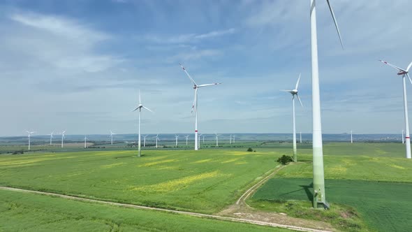 Aerial view of wind turbine spinning in green field