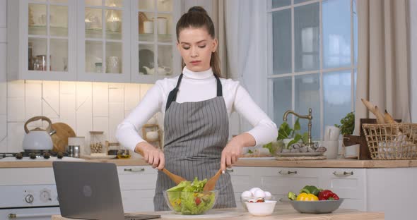 Young Woman Apron Cooking Salad Kitchen Watching Video Recipe Laptop Online