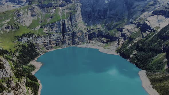 Oeschinen Lake and the surrounding mountains drone shot on a sunny summer day