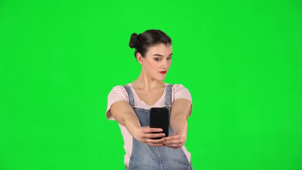 Girl Makes Selfie on Mobile Phone Then Looking Photos on Green Screen