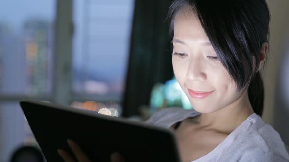 Woman watching on digital tablet at night