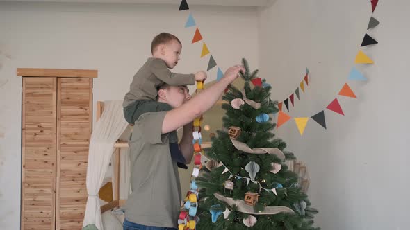 Father with Little Son Decorating Christmas Tree